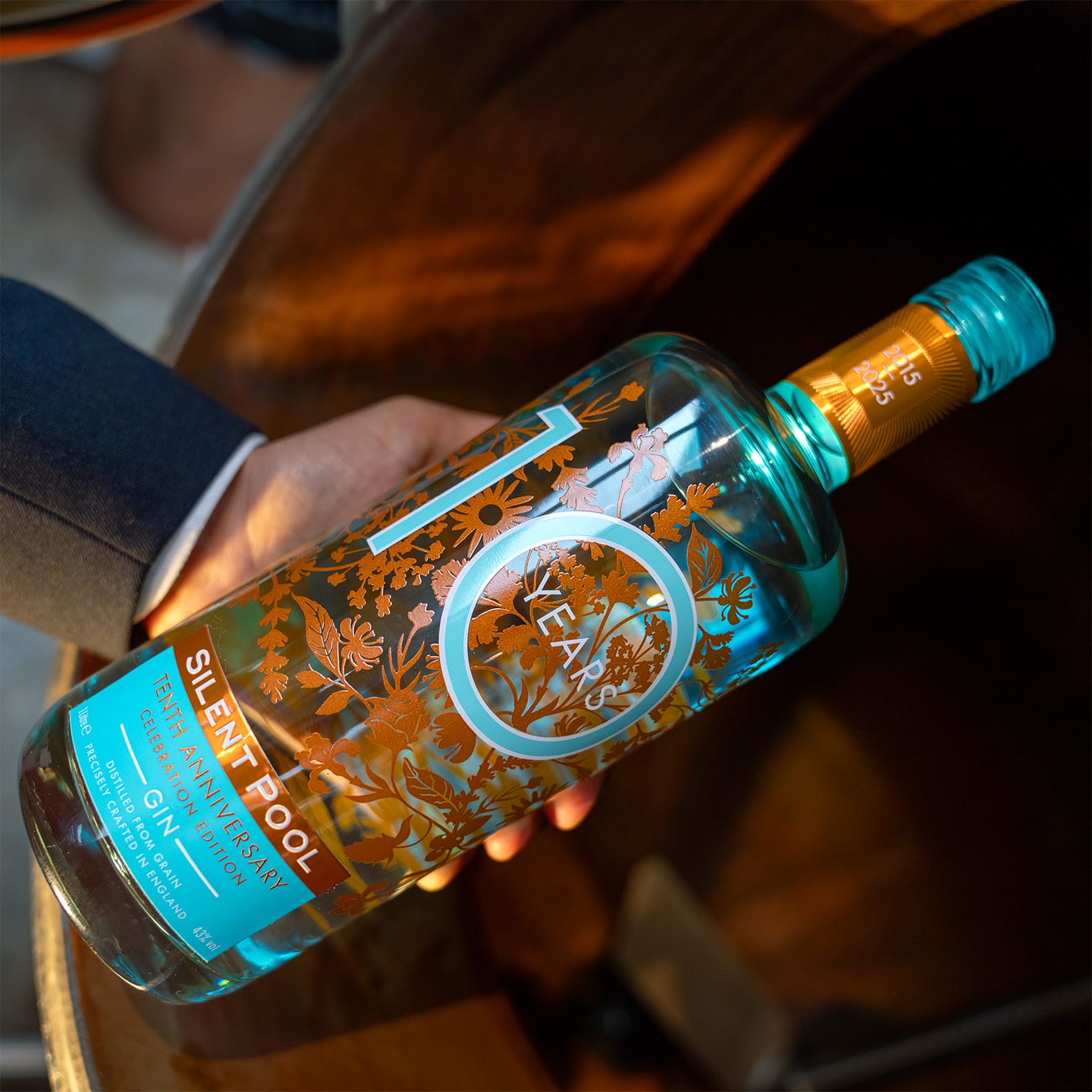 A teal coloured bottle with copper plants printed and the number '10'.