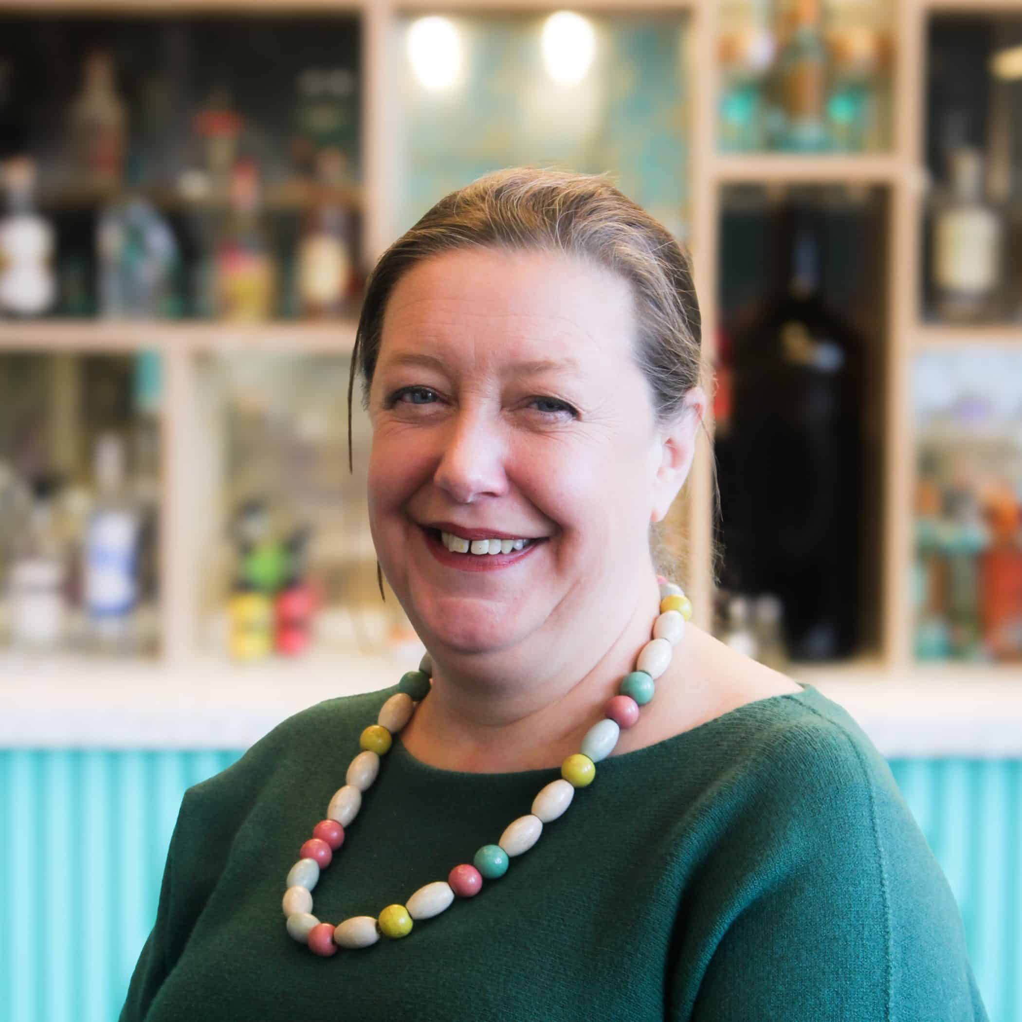 Veronica Chambers, smiling in front of the Croxsons bar